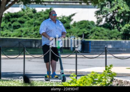 Un uomo di grandi dimensioni che guida uno scooter elettrico Lime-S sulla East Basin Drive SW a Washington DC. Foto Stock