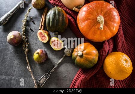 Foto dall'alto di butternut, zucca gemma, zucca, nocciolo dorato, carota, fichi, patate dolci, cipolla, arance e prezzemolo. Concetto di alimentazione sana. Foto Stock