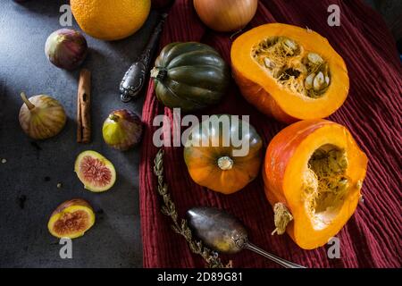 Foto dall'alto di butternut, zucca gemma, zucca, nocciolo dorato, carota, fichi, patate dolci, cipolla, arance e prezzemolo. Concetto di alimentazione sana. Foto Stock