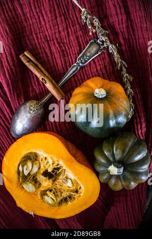 Foto dall'alto di butternut, zucca gemma, zucca, nocciolo dorato, carota, fichi, patate dolci, cipolla, arance e prezzemolo. Concetto di alimentazione sana. Foto Stock