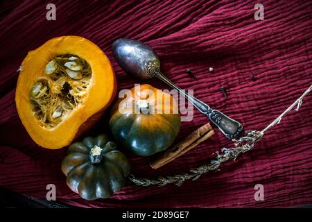 Foto dall'alto di butternut, zucca gemma, zucca, nocciolo dorato, carota, fichi, patate dolci, cipolla, arance e prezzemolo. Concetto di alimentazione sana. Foto Stock