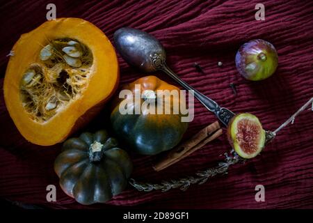 Foto dall'alto di butternut, zucca gemma, zucca, nocciolo dorato, carota, fichi, patate dolci, cipolla, arance e prezzemolo. Concetto di alimentazione sana. Foto Stock