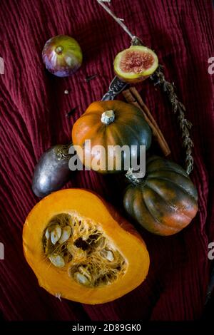 Foto dall'alto di butternut, zucca gemma, zucca, nocciolo dorato, carota, fichi, patate dolci, cipolla, arance e prezzemolo. Concetto di alimentazione sana. Foto Stock