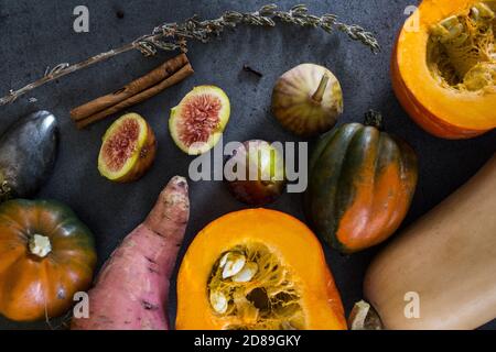 Verdure fresche su sfondo grigio con spazio per la copia. Foto dall'alto di butternut, zucca gemma, carota di zucca d'oro, fichi, patate dolci, cipolla. Foto Stock