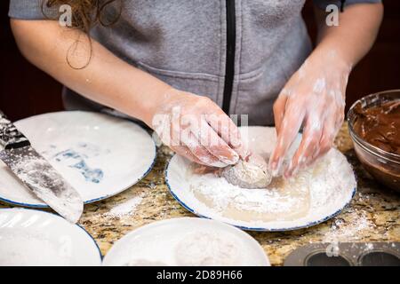 Donna che cucina formando pezzo di mochi fatto in casa glutinoso appiccicoso Dolce giapponese torta di riso in cucina con ripieno di cioccolato sporco mani Foto Stock