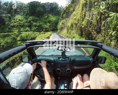 Vista posteriore di una coppia che guida una vettura convertibile, Maui, Hawaii, USA Foto Stock