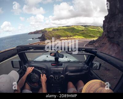 Vista posteriore di una coppia che guida una vettura convertibile, Maui, Hawaii, USA Foto Stock