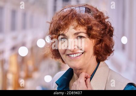 Felice ritratto donna anziana bianco all'interno del centro commerciale. Foto Stock