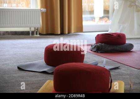 Sala yoga con tappetini e cuscini senza persone Foto Stock