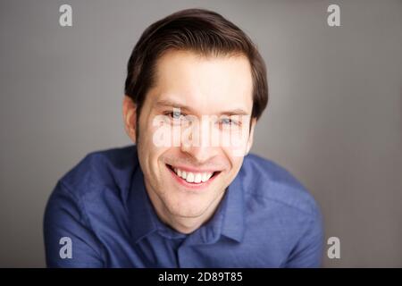 Primo piano ritratto di un attraente uomo d'affari sorridente con fiducia Foto Stock