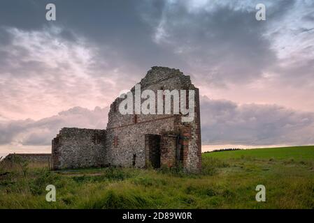 Rovinato edificio agricolo contro un cielo drammatico sulle Downs Sussex. Foto Stock