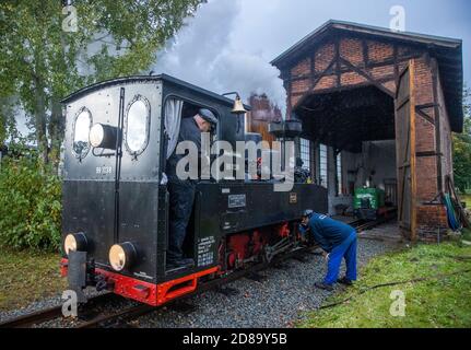 17 ottobre 2020, Meclemburgo-Pomerania occidentale, Klütz: Sotto la pioggia, la locomotiva brigata di 102 anni è in preparazione per il suo primo viaggio alla stazione. Fino al 19.10.2020 la locomotiva trarrà il treno passeggeri sulla linea ferroviaria leggera "Kaffeebrenner". Alla fine della stagione sul treno turistico con 600 millimetri di carreggiata, una storica locomotiva a vapore percorrerà la linea. Il treno viaggerà a 20 chilometri all'ora sulla tratta di soli sei chilometri tra Klütz e Reppenhagen. La linea ferroviaria nel Meclemburgo nord-occidentale è stata aperta il 6 giugno 1905 con il nome di "Grand-Ducal-Meclemburgo" Foto Stock