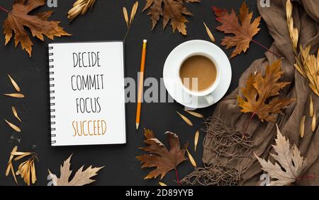 Blocco note con parole decidere, commettere e successo, sfondo nero autunno Foto Stock