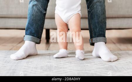 Padre e bambino piccolo toddler che si levano insieme a casa, corto Foto Stock
