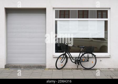 cartello vuoto o poster con spazio per la copia vuoto vetrina con biciclette parcheggiate all'esterno del negozio chiuso Foto Stock