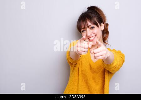 Ritratto di giovane donna allegra che punta il dito verso di te Foto Stock