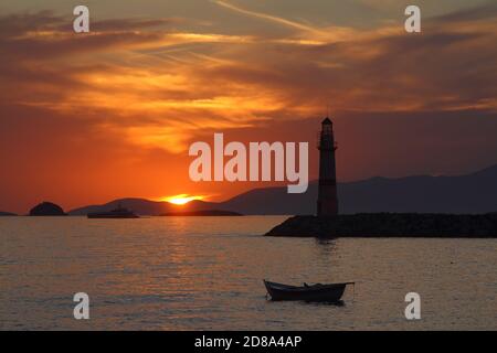 Seascape al tramonto. Faro sulla costa. Città balneare di Turgutreis e tramonti spettacolari Foto Stock