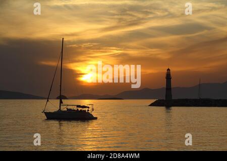 Seascape al tramonto. Faro sulla costa. Città balneare di Turgutreis e tramonti spettacolari Foto Stock