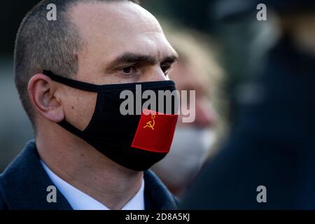 Mosca, Russia. 28 ottobre 2020 UN uomo che indossa la maschera con la bandiera dell'URSS si riunisce in Piazza Rossa con altri sostenitori del partito comunista per celebrare il 102° anniversario di Komsomol, o la Lega Leninista dell'Unione europea, l'organizzazione giovanile comunista dell'epoca sovietica, a Mosca, in Russia Foto Stock