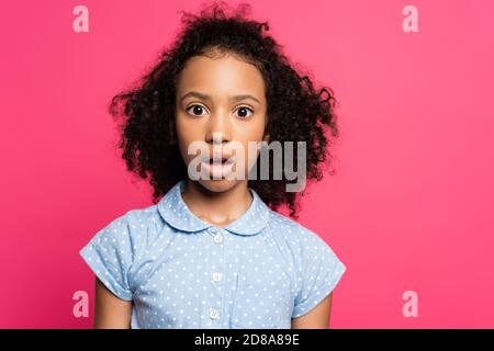 scioccato carino curly africano americano capretto con bocca aperta isolato su rosa Foto Stock