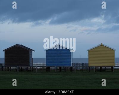 Leysdown, Kent, Regno Unito. 28 ottobre 2020. UK Weather: Nuvole di pioggia oscure minacciose si profilano sulle capanne della spiaggia a Leysdown, Kent questa sera. Credit: James Bell/Alamy Live News Foto Stock
