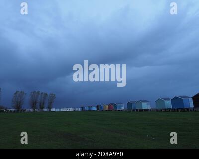 Leysdown, Kent, Regno Unito. 28 ottobre 2020. UK Weather: Nuvole di pioggia oscure minacciose si profilano sulle capanne della spiaggia a Leysdown, Kent questa sera. Credit: James Bell/Alamy Live News Foto Stock