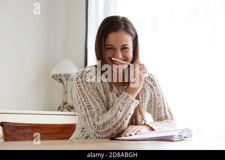 Ritratto di una studentessa sorridente che lavora a casa Foto Stock