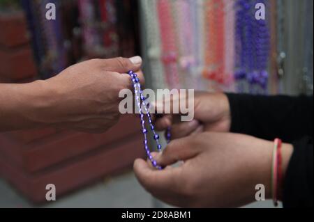 I commercianti vendono gli accessori religiosi del Signore dei Miracoli Foto Stock