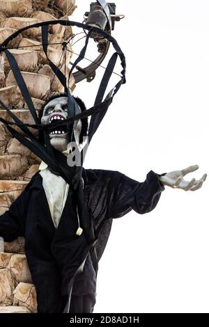 Halloween urlando la decorazione del burattino del mostro zombie appeso su un tronco di palma a Dubai, Emirati Arabi Uniti. Foto Stock