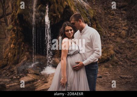 Uomo di famiglia con una donna incinta con un grande ventre in natura Foto Stock