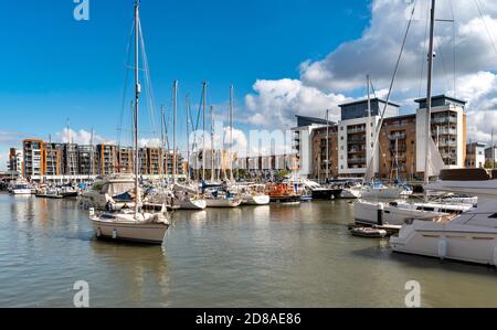 PORTISHEAD BRISTOL SOMERSET ENGLAND MARINA CON UNO YACHT CHE PASSA LE BARCHE ORMEGGIATE E LA CASA GALLEGGIANTE Foto Stock