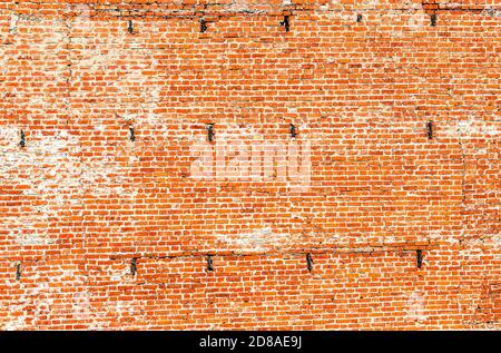 Muro di mattoni rossi del Cremlino medievale di Kolomna come struttura di sfondo. Muro di mattoni fessurato dagli agenti atmosferici Foto Stock