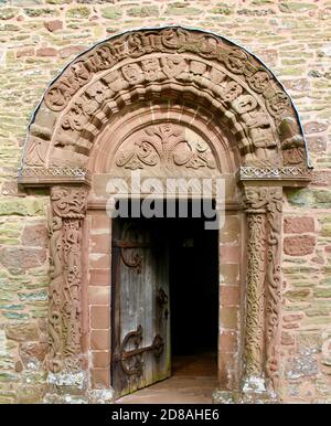 Questa è la bella porta sud della Chiesa Parrocchiale Di Santa Maria e di San Davide a Kilpeck in Herefordshire Foto Stock