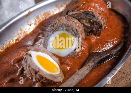 Un piatto tipico siciliano: Il Falsomagro (detto anche Brociolone) farcito con uovo bollito e salsa di pomodoro Foto Stock