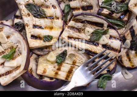 Cucina siciliana: Shot dall'alto di melanzane tunisine alla griglia e condite con olio d'oliva, aglio e menta fresca Foto Stock