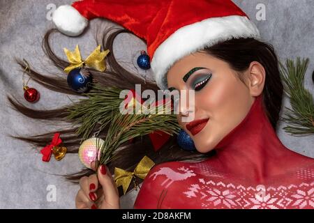 Una bella brunetta con make-up artistico e con una Santa Cappello di Claus Foto Stock