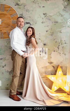 Foto in studio di una giovane coppia sposata. Un ragazzo con una ragazza in abiti festosi festeggia Natale. Storia d'amore di Capodanno. Il nuovo Ye Foto Stock