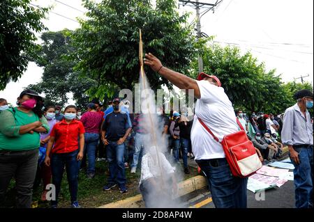 San Salvador, El Salvador. 28 Ott 2020. Un dimostratore spara una casa fatto fuoco durante una protesta che chiede il pagamento del fondo FODES.Pagamenti per oltre 240 milioni di dollari sono ancora stati fatti dal governo e i comuni rischiano di perdere l'elettricità e altri servizi municipali. Credit: Camilo Freedman/ZUMA Wire/Alamy Live News Foto Stock