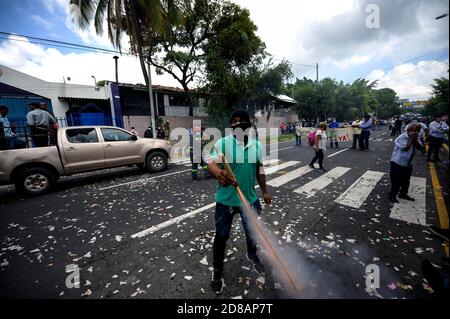 San Salvador, El Salvador. 28 Ott 2020. Un dimostratore spara una casa fatto fuoco durante una protesta che chiede il pagamento del fondo FODES.Pagamenti per oltre 240 milioni di dollari sono ancora stati fatti dal governo e i comuni rischiano di perdere l'elettricità e altri servizi municipali. Credit: Camilo Freedman/ZUMA Wire/Alamy Live News Foto Stock