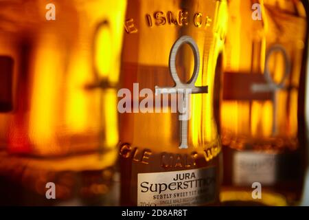 File di bottiglie Whisky con luce dorata Foto Stock