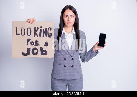 Foto di attraente infornato insurset manager signora tenere telefono cartone placard cercare lavoro preparare gadget per ricevere l'offerta di colloquio di chiamata vuoi un abbigliamento da formalwear Foto Stock