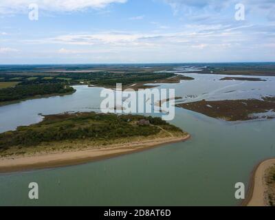 Vista aerea della splendida laguna di Caorle vicino a Venezia, con vecchie case dei pescatori, gente che si gode l'estate in spiaggia e barche che passano Foto Stock