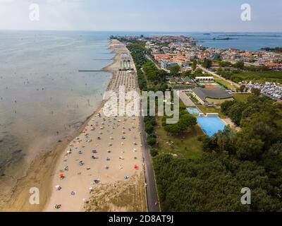 Vista aerea di persone non identificabili che si godono l'estate in spiaggia Grado nella provincia di Gorizia a nord Mare Adriatico Foto Stock