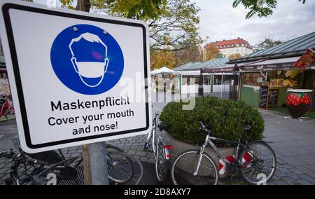 Monaco, Germania. 28 Ott 2020. Un segno con l'iscrizione 'Maskspflicht - coprire la bocca e il naso!' Si trova all'entrata del Viktualienmarkt nel centro della città. Credit: Peter Kneffel/dpa/Alamy Live News Foto Stock