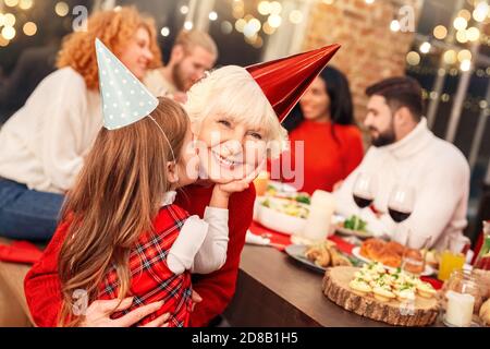 Ragazzina baciando la nonna felice Foto Stock