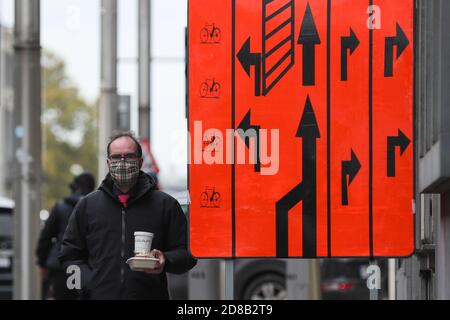 Bruxelles, Belgio. 28 Ott 2020. Un uomo che indossa una maschera cammina su una strada a Bruxelles, Belgio, il 28 ottobre 2020. L'istituto di salute belga Sciensano ha rilasciato mercoledì la cifra di morte COVID-19 di 104 registrata il lunedì, il numero più alto giornaliero dall'inizio della seconda ondata. Credit: Zheng Huansong/Xinhua/Alamy Live News Foto Stock