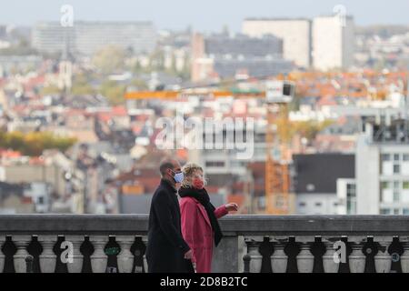 Bruxelles, Belgio. 28 Ott 2020. Le persone che indossano maschere facciali camminano su una strada a Bruxelles, Belgio, il 28 ottobre 2020. L'istituto di salute belga Sciensano ha rilasciato mercoledì la cifra di morte COVID-19 di 104 registrata il lunedì, il numero più alto giornaliero dall'inizio della seconda ondata. Credit: Zheng Huansong/Xinhua/Alamy Live News Foto Stock