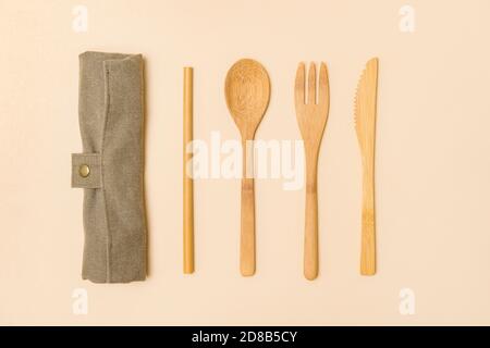 Set di posate eco-friendly di bambù su sfondo color cammello. Concetto privo di plastica. Primo piano, vista dall'alto. Foto Stock