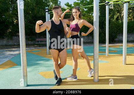 Giovane uomo e donna in posa in un parco calistenico sopra una giornata di sole Foto Stock