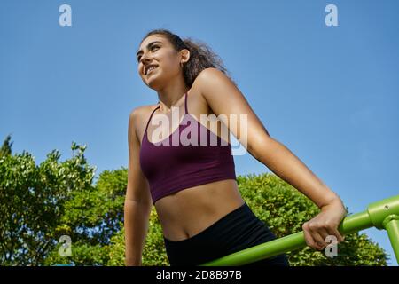 Giovane donna che pratica calistenici su barre orizzontali Foto Stock